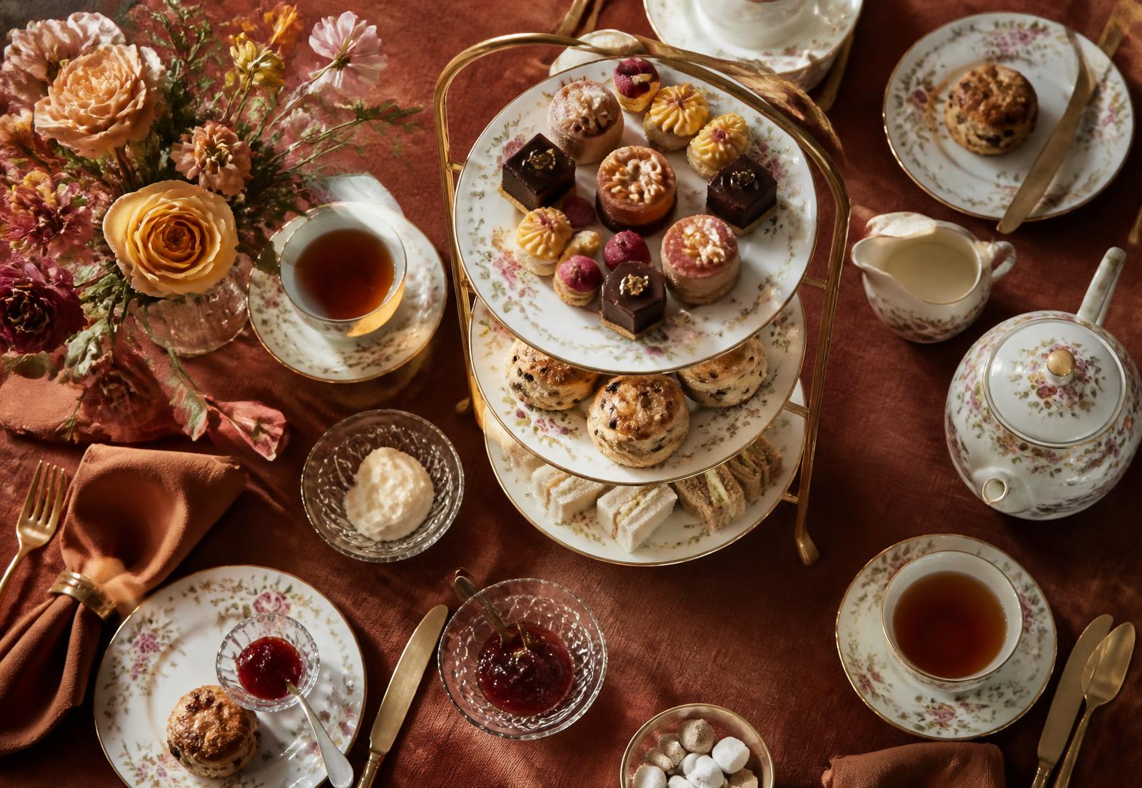 Overhead view of an elegant afternoon tea table with tiered stand and florals